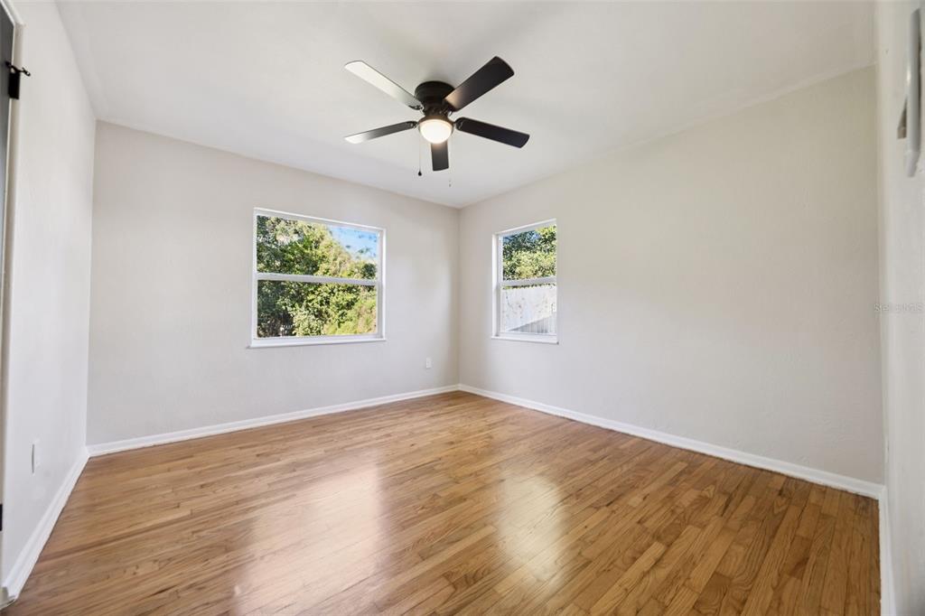 1001 Alton Avenue Orlando, FL 32804 - Photo 12 of 20 an empty room with wooden floor ceiling fan and windows