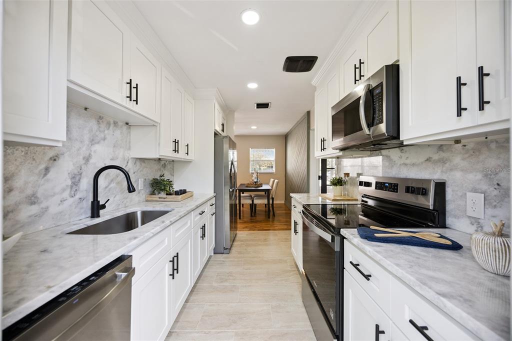 1001 Alton Avenue Orlando, FL 32804 - Photo 6 of 20 a kitchen with stainless steel appliances granite countertop a sink a stove and cabinets
