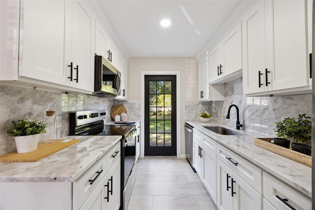 1001 Alton Avenue Orlando, FL 32804 - Photo 7 of 20 a kitchen with granite countertop a sink stainless steel appliances and cabinets