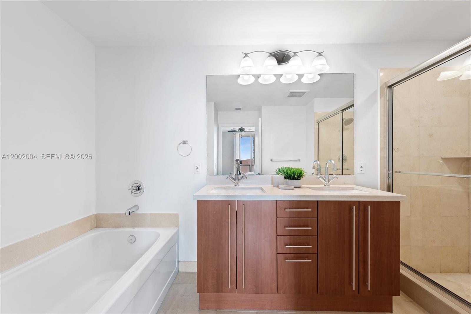 79 Southwest 12th Street, Unit 2503S Miami, FL 33130 - Photo 11 of 27 a bathroom with a granite countertop sink a large mirror and a bathtub
