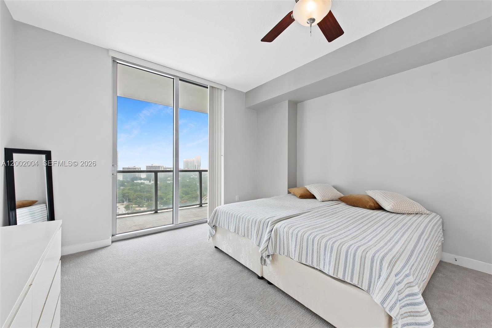 79 Southwest 12th Street, Unit 2503S Miami, FL 33130 - Photo 15 of 27 a bedroom with a large bed and a chandelier