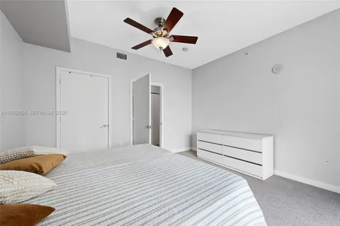 a bedroom with a bed and a ceiling fan