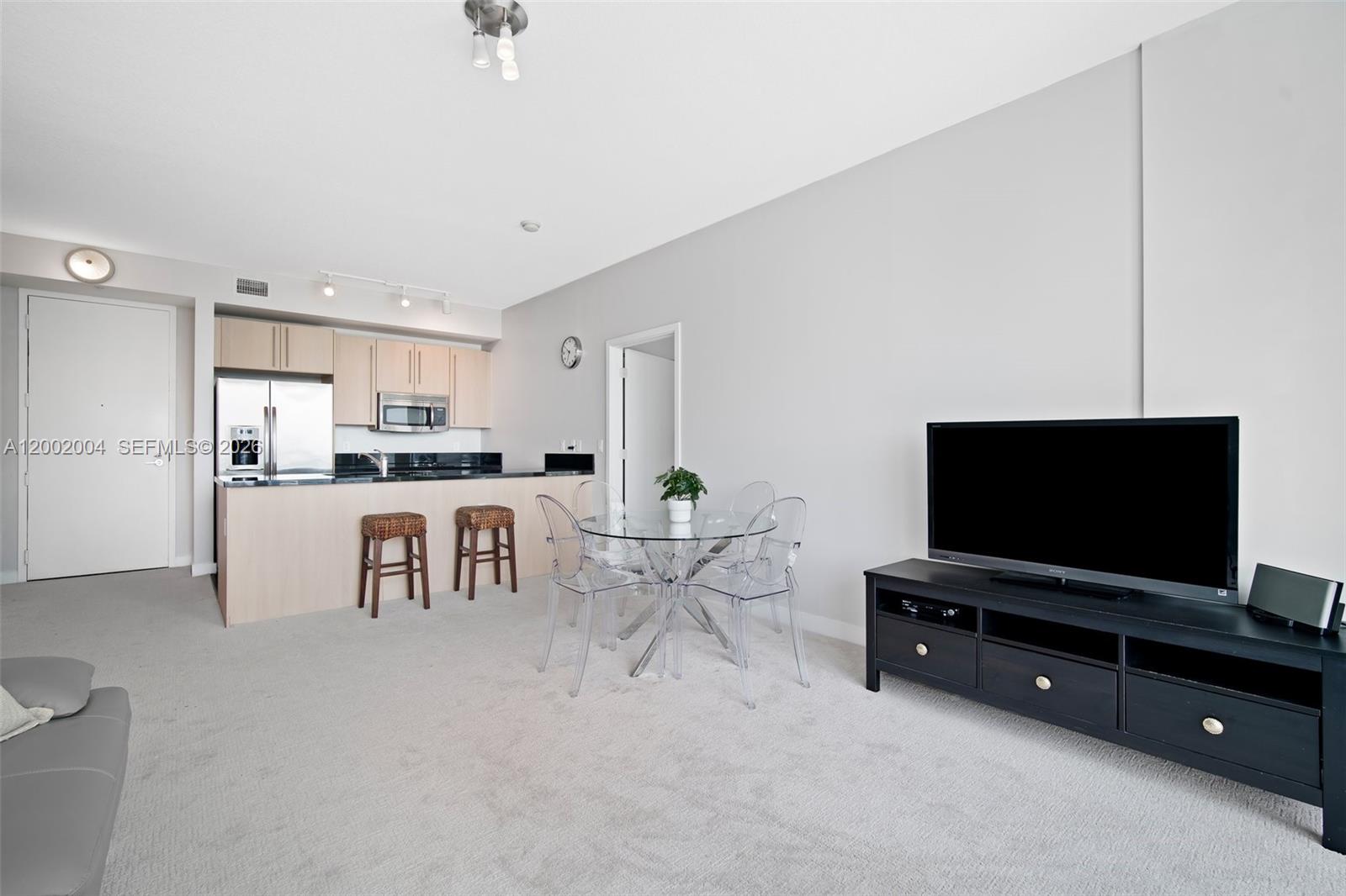 79 Southwest 12th Street, Unit 2503S Miami, FL 33130 - Photo 3 of 27 a living room with furniture and a flat screen tv