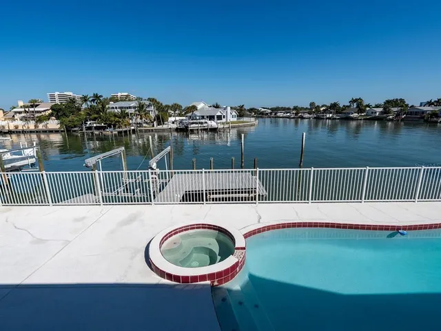 an aerial view of residential houses with outdoor space and lake view