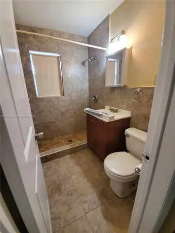 a bathroom with a granite countertop toilet a sink and a shower