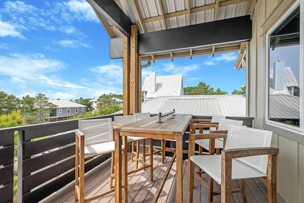 a view of roof deck with chairs and wooden fence