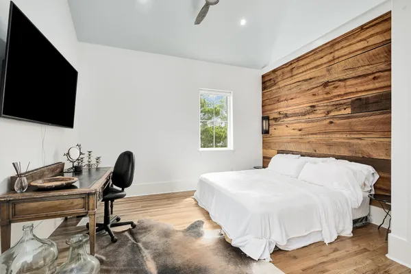 a bedroom with a bed and a flat screen tv