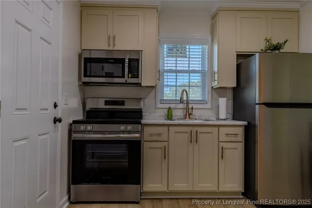 a kitchen with cabinets stainless steel appliances and a counter space