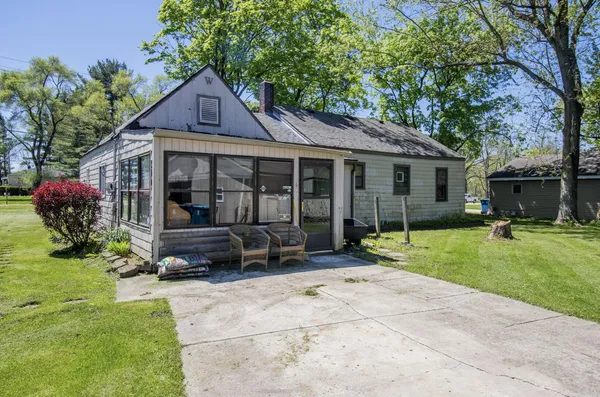 a view of a house with a yard and sitting area