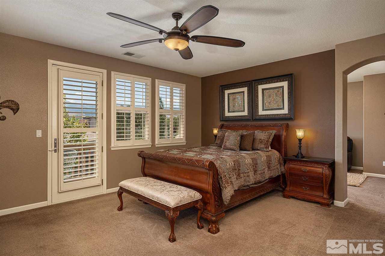 490 Oldenburg Drive Reno, NV 89521 - Photo 12 of 25 a bedroom with a bed and a chandelier