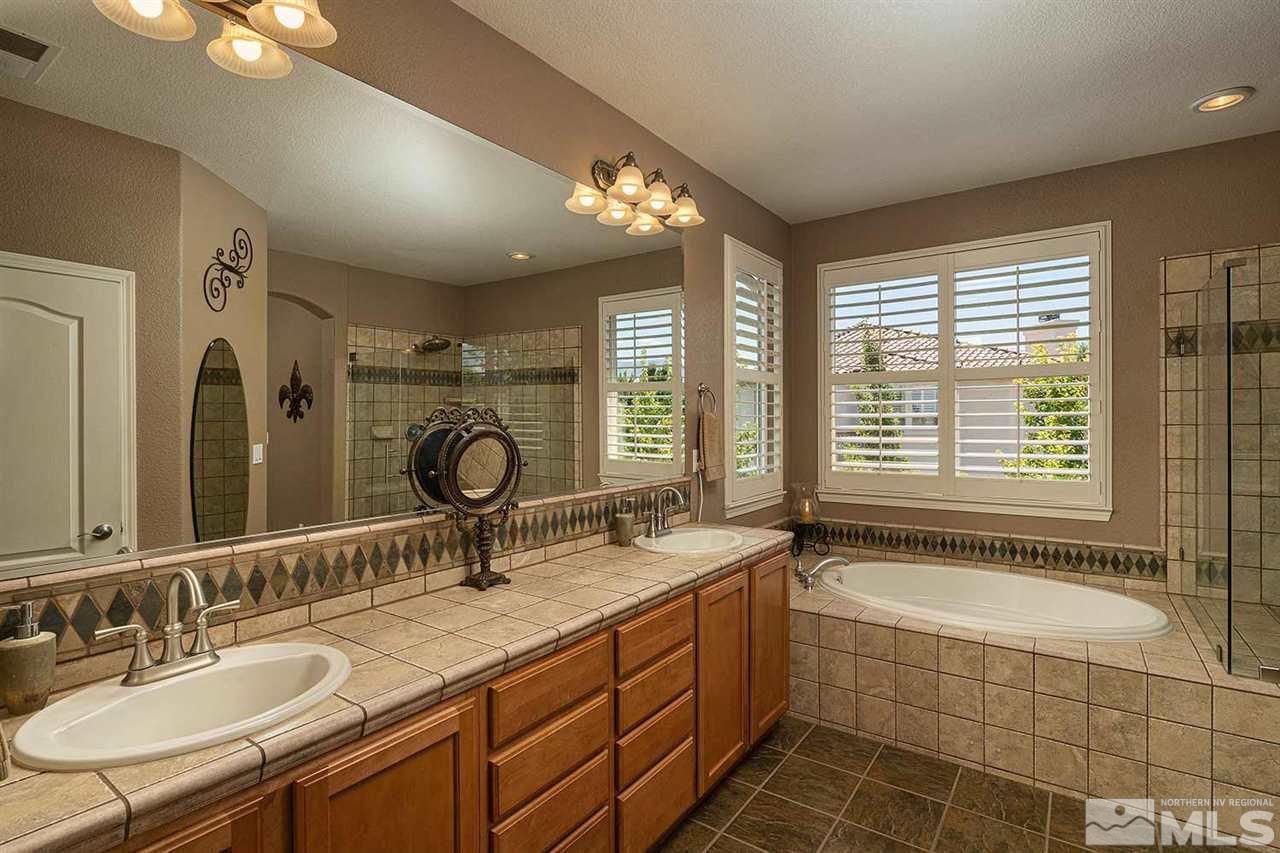 490 Oldenburg Drive Reno, NV 89521 - Photo 13 of 25 a bathroom with a granite countertop sink a large mirror and a bathtub