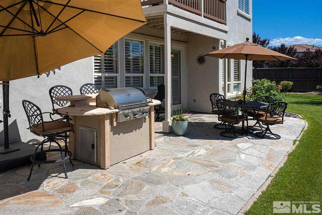 490 Oldenburg Drive Reno, NV 89521 - Photo 23 of 25 a view of a patio with table and chairs under an umbrella