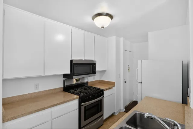 a kitchen with stainless steel appliances a stove a microwave and a refrigerator