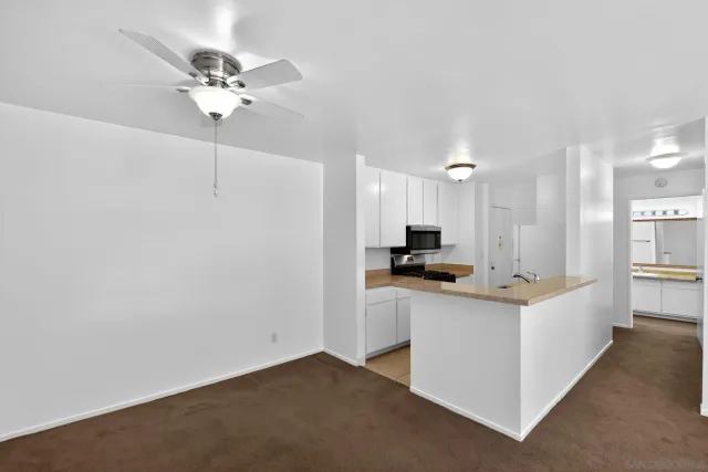 a view of kitchen with sink and refrigerator