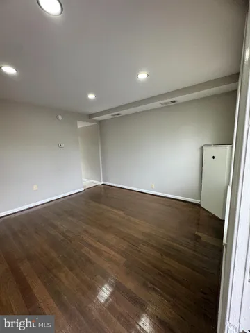 an empty room with wooden floor and entrance