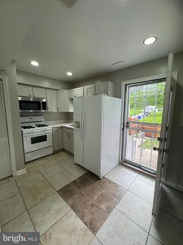 a kitchen with stainless steel appliances granite countertop a refrigerator oven a sink and dishwasher