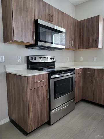 a kitchen with granite countertop wooden cabinets and stainless steel appliances
