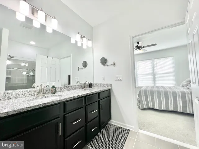 a bathroom with a double vanity sink a mirror and a bathtub