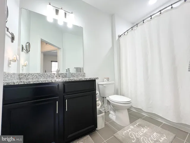 a bathroom with a sink vanity mirror and toilet