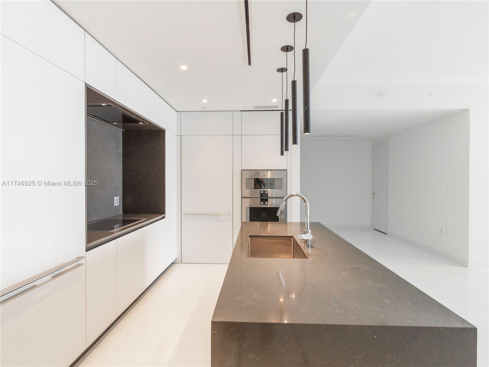 300 Biscayne Boulevard, Unit 4305 Miami, FL 33132 - Photo 28 of 32 a view of a kitchen with a sink and dishwasher with a living room