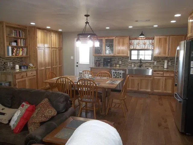 a kitchen with kitchen island granite countertop a sink a center island stainless steel appliances and cabinets