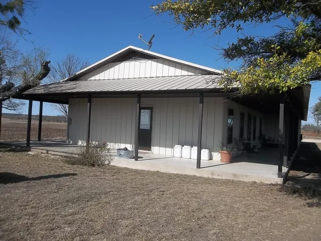 a backyard of a house with table and chairs