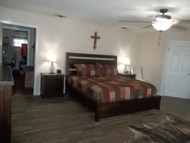 a bedroom with a large bed and a chandelier