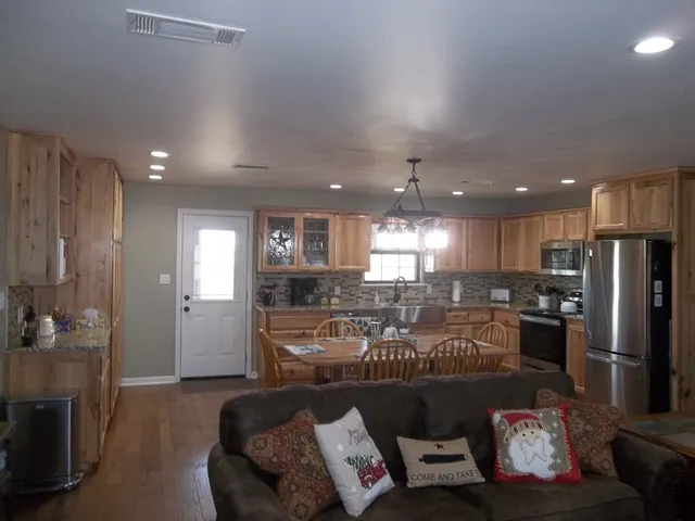 a kitchen with a dining table chairs stainless steel appliances and cabinets
