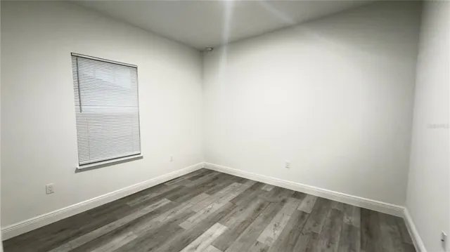 a view of a small space with wooden floor and a window