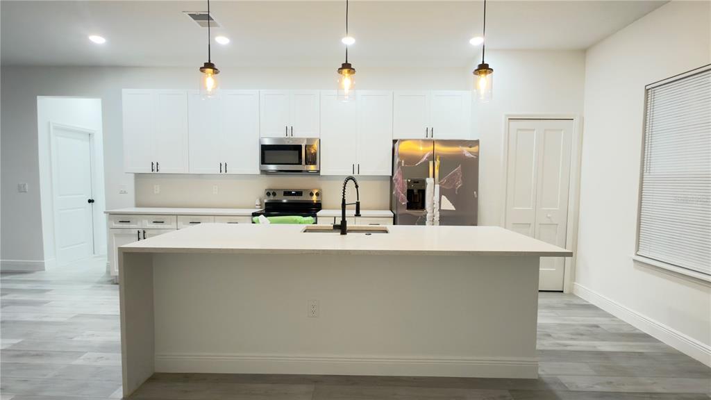 13047 Southwest 79th Circle Ocala, FL 34473 - Photo 5 of 29 a kitchen with stainless steel appliances a sink a stove a refrigerator and cabinets