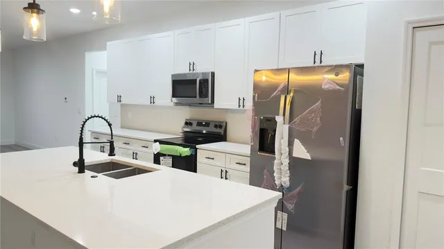 a kitchen with stainless steel appliances a sink a stove and a refrigerator