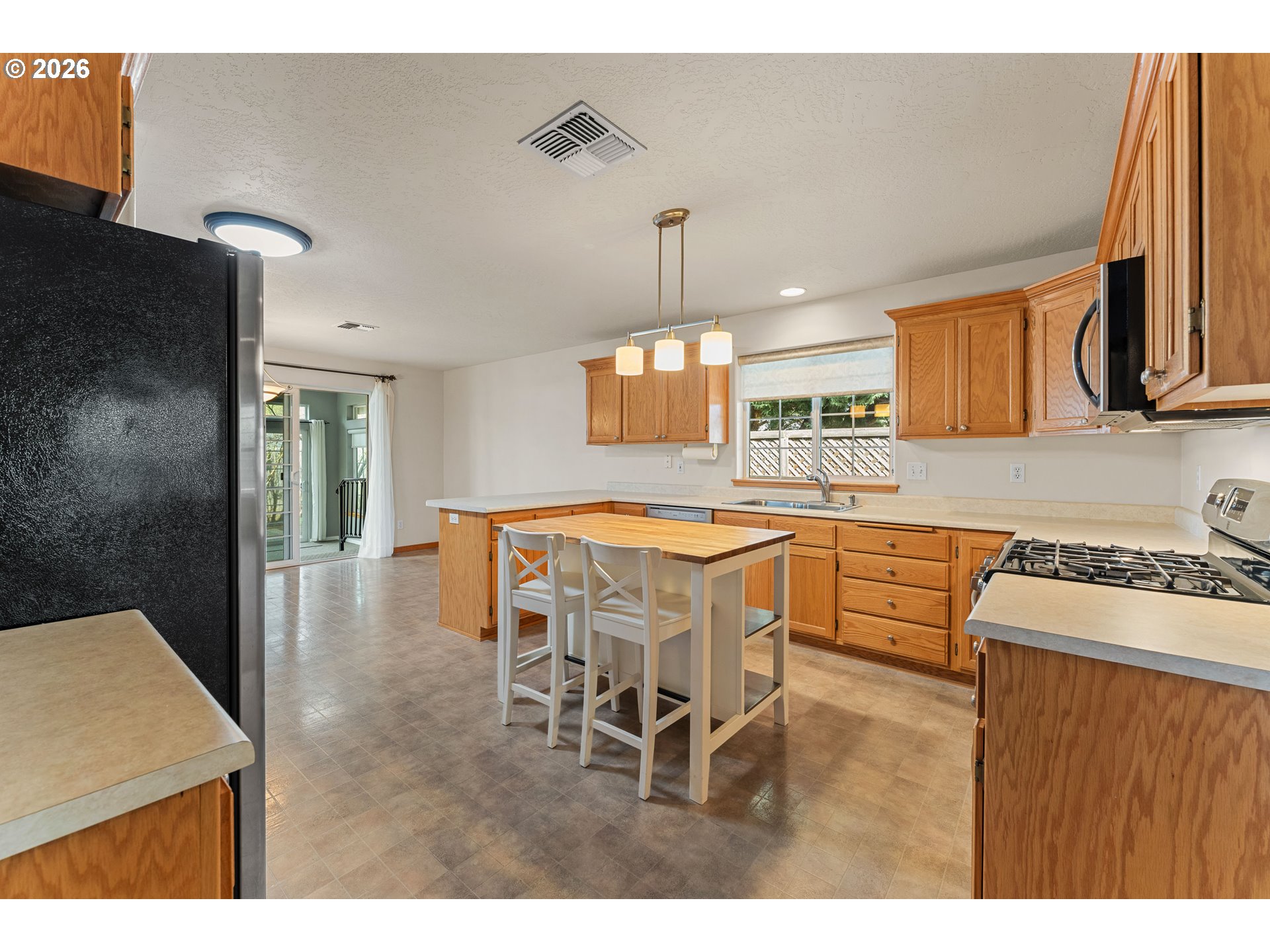2188 Marie Drive Grants Pass, OR 97526 - Photo 11 of 27 a kitchen with stainless steel appliances kitchen island granite countertop a sink and a refrigerator