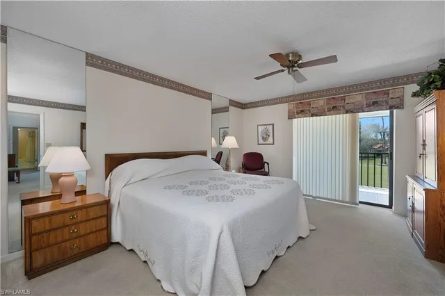 a spacious bedroom with a bed a lamp and a large window