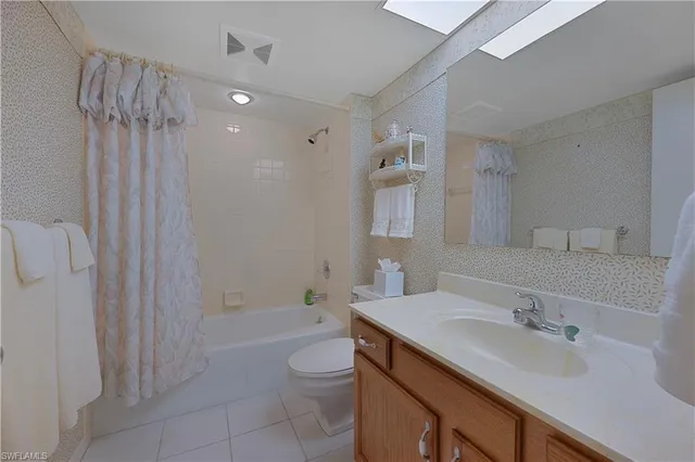 a bathroom with a sink a toilet a mirror and shower