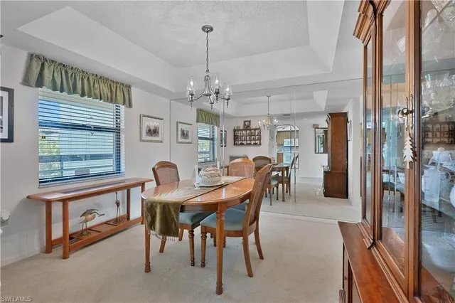 a view of a dining room with furniture and a chandelier