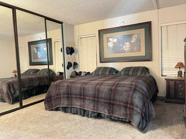 a bedroom with a bed lamp closet and large window