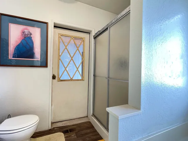 a bathroom with a painting on the wall and a shower