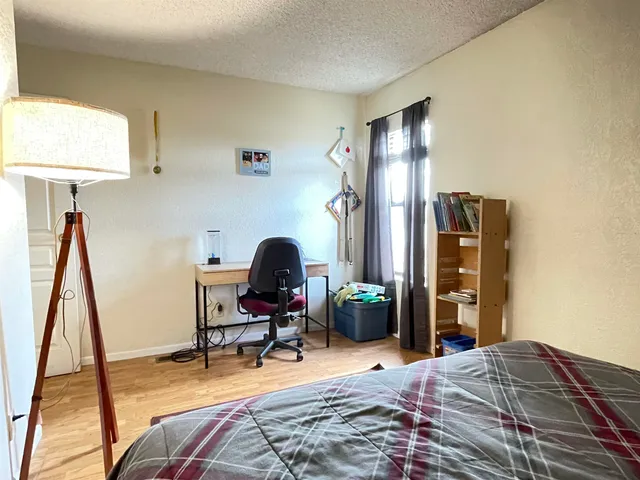 a bedroom with a bed and a flat tv screen on the dresser