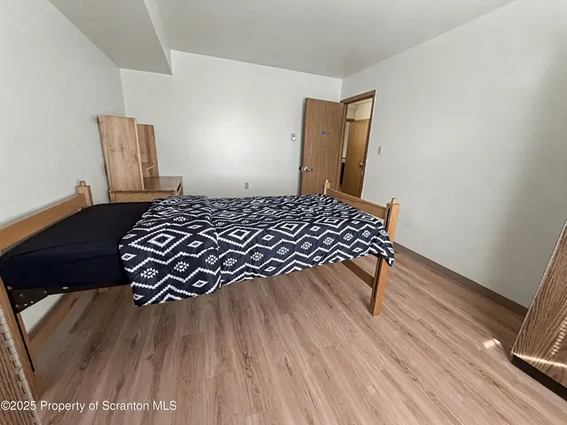a bedroom with a bed and wooden floor