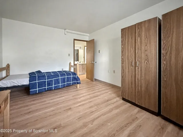 a view of a bedroom with wooden floor and closet