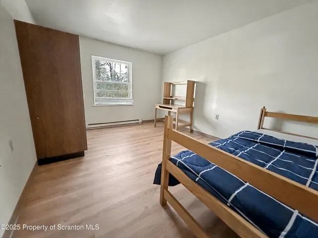 a room with wooden floor and paintings on the wall