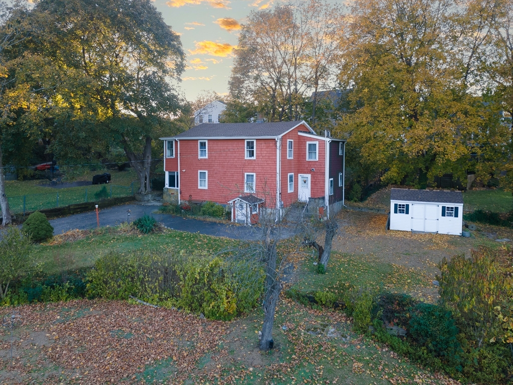 a view of a yard in front of a house with large trees