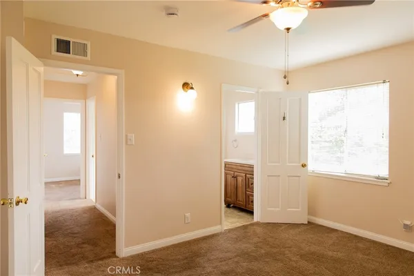 a view of an empty room with window chandelier fan
