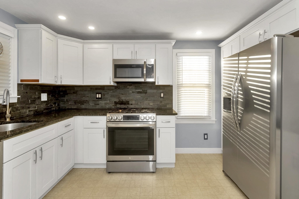 154 Ellsworth Avenue Springfield, MA 01118 - Photo 9 of 22 a kitchen with stainless steel appliances granite countertop a stove a sink and a microwave