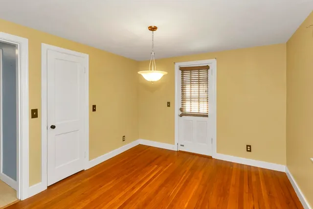 a view of a room with wooden floor and window