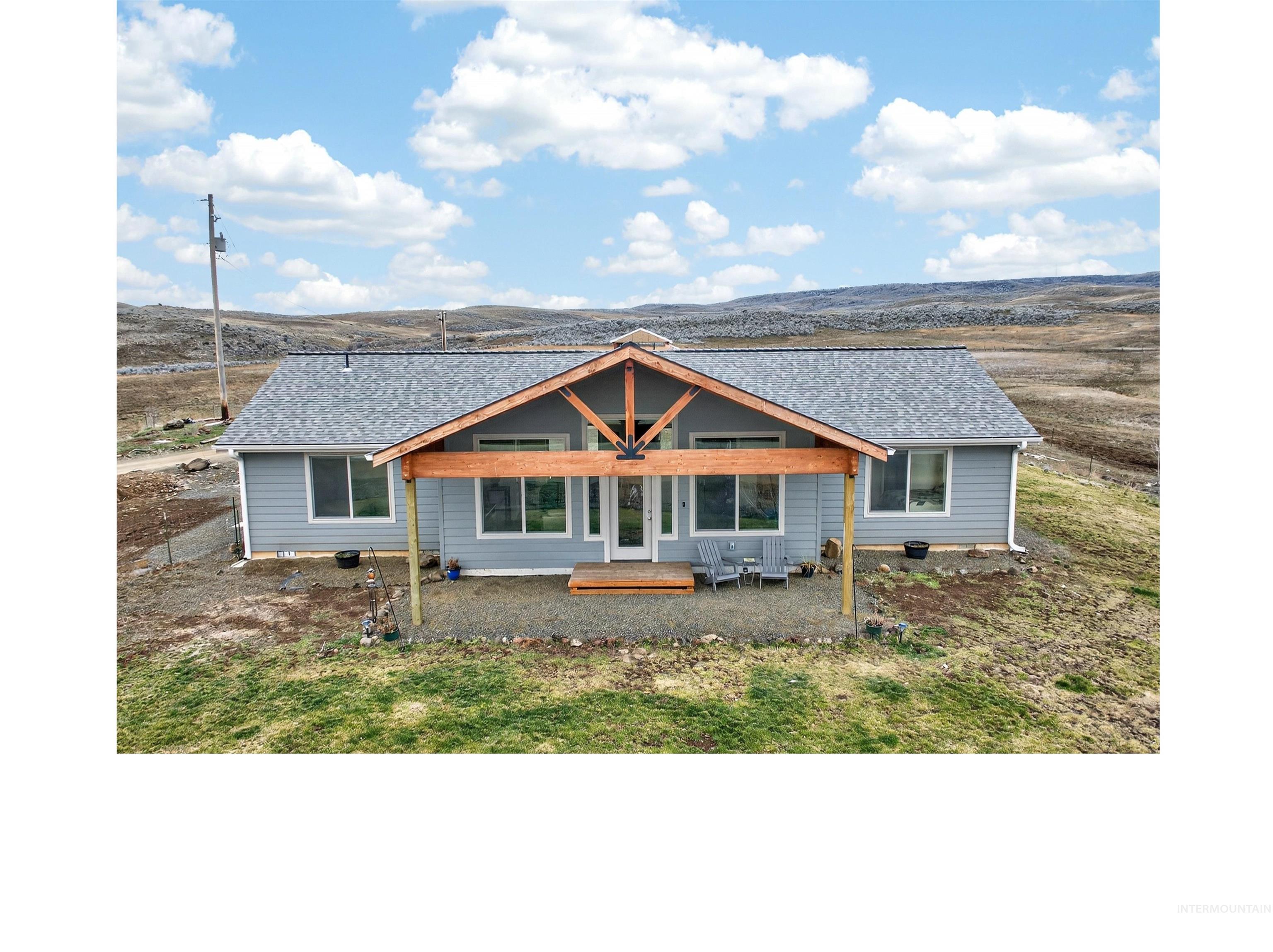 View of front of house with a patio and a shingled roof