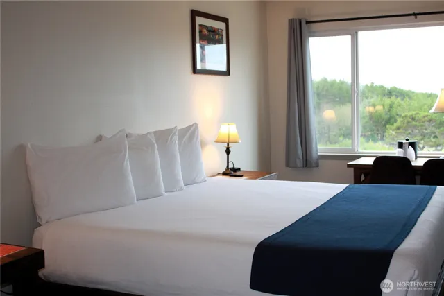 a bedroom with a bed and a large window