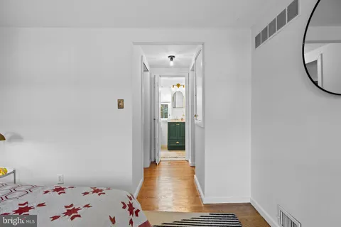 a view of a hallway to a livingroom with wooden floor and a window