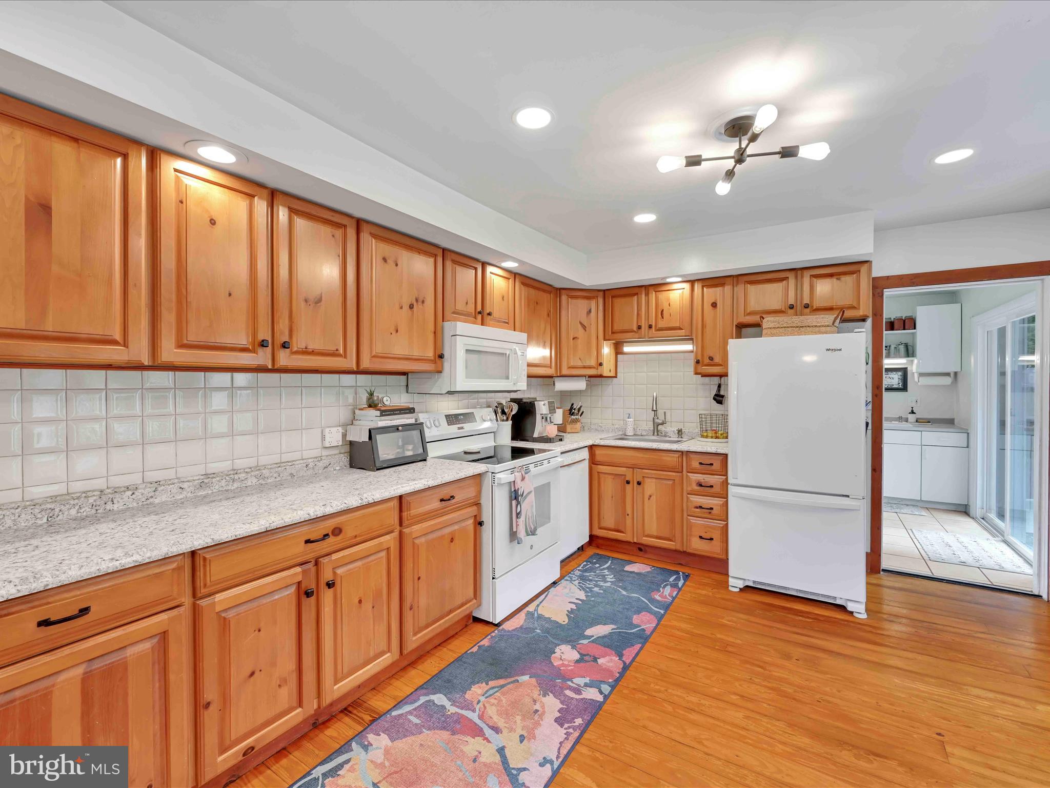 1036 Baker Road Reading, PA 19608 - Photo 14 of 44 a kitchen with granite countertop stainless steel appliances a refrigerator cabinets and wooden floor