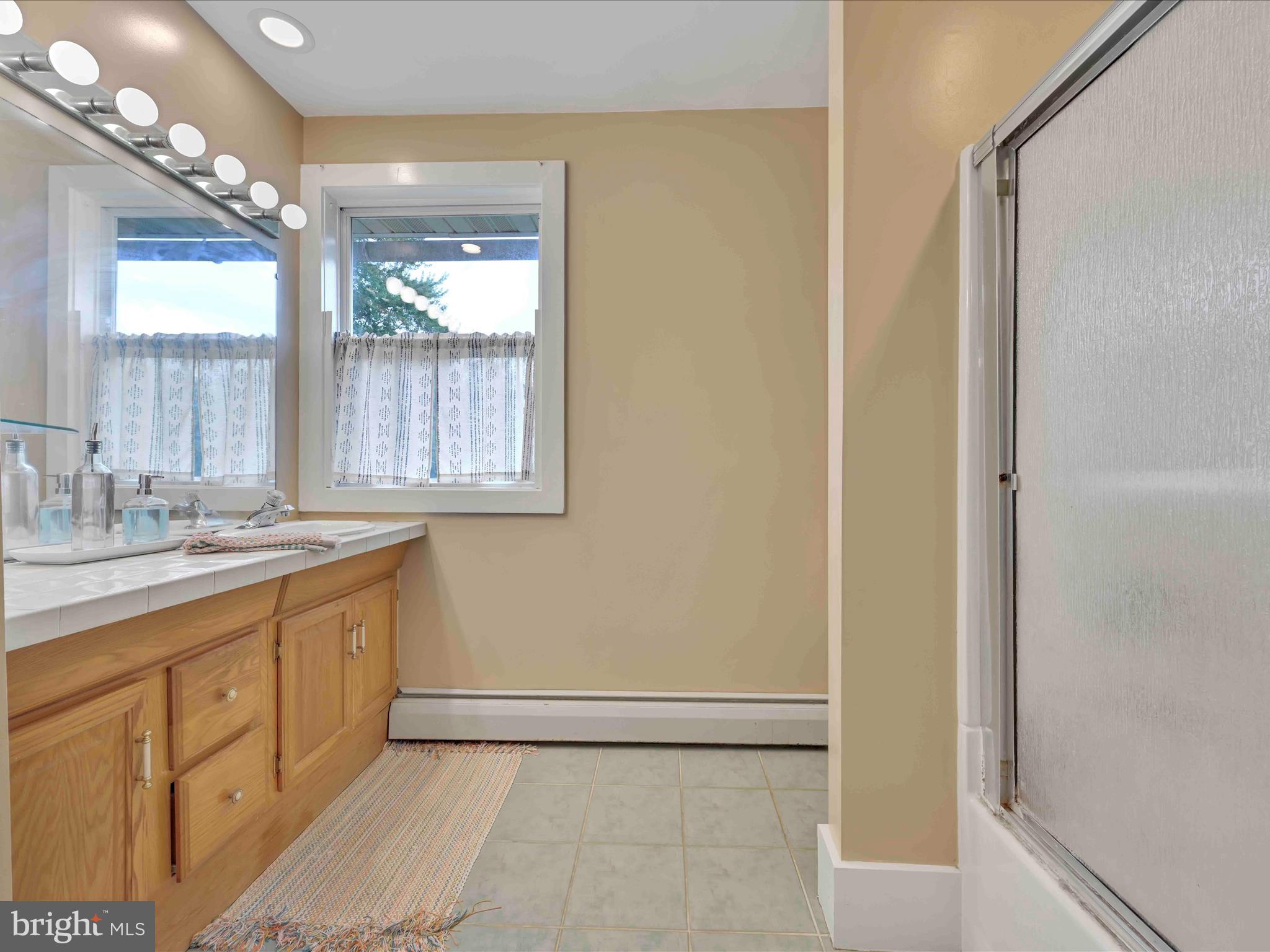 1036 Baker Road Reading, PA 19608 - Photo 23 of 44 a bathroom with a granite countertop sink a mirror and a shower